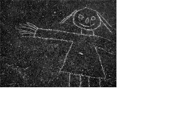 Detalhe de uma boneca ou menina desenhada com giz branco sobre uma superfície de asfalto escura, quase preta, com pedrinhas brancas muito pequenas. O desenho parece ter sido feito por uma criança.