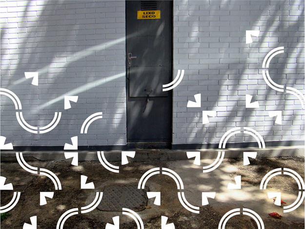 Foto horizontal de uma parede de tijolinhos brancos com uma porta estreita e cinza chumbo, bem no centro, com uma pequena placa amarela diz "lixo seco". Na parte de baixo há uma calçada de cimento marrom. A fachada e o chão estão na sombra, com pequenas áreas onde a luz do sol forma desenhos. Sobre a metade inferior da imagem foram colados grafismos brancos de um azulejo de Athos Bulcão, composto por dois estreitos arcos de círculo e uma forma que lembra uma ponta de flecha. Eles foram colocados em diferentes posições sobre toda a metade de baixo e vão rareando do meio para cima, sem chegar à margem de cima da foto.