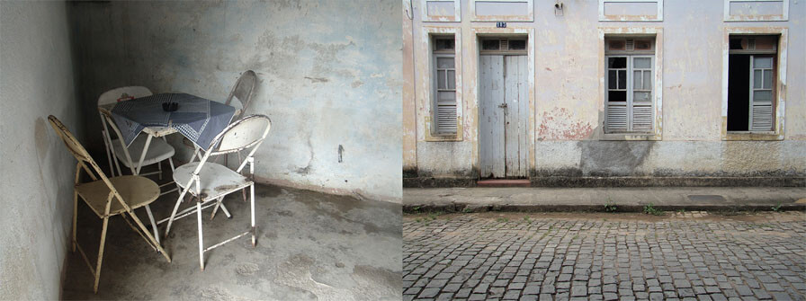 As duas fotos têm tons de azul e cinza, cores claras e desbotadas. A da direita mostra uma rua com calçamento de pedra cinza, uma calçada e a fachada de uma casa com uma janela estreita demais, uma porta e duas outras janelas estreitas e altas. A casa é antiga e está bem degradada pelo tempo. A foto da esquerda mostra uma pequena mesa de bar quadrada, de ferro, com quatro cadeiras e uma toalhinha de plástico, num canto formado por duas paredes. O canto é escuro e tem um ângulo que causa estranheza, pois é bem menor que 90 graus. O chão é de cimento e tudo é velho, desbotado e descascado. 