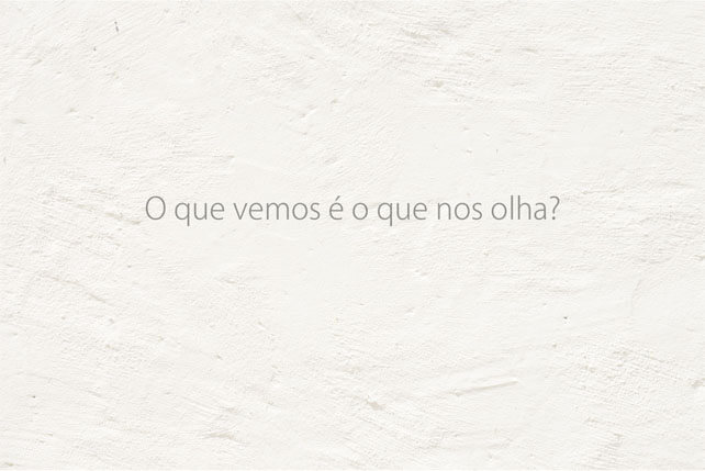 Imagem horizontal de uma parede branca com a terceira frase: O que vemos é o que nos olha?