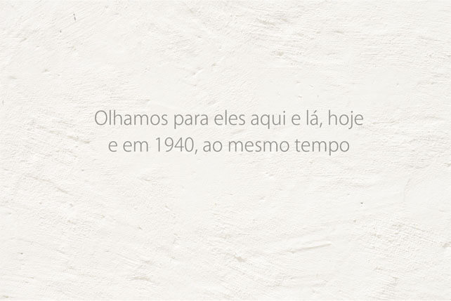 Imagem horizontal de uma parede branca com a nona frase: Olhamos para eles aqui e lá, hoje e em 1940, ao mesmo tempo.