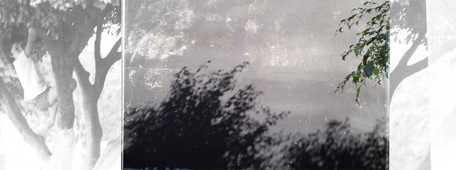 Colagem digital em formato panorâmico. À esquerda há uma foto vertical, preto e branca, de uma criança de três anos subindo numa árvore, vista de perto. No centro há uma foto horizontal de uma parede preta, desbotada e com manchas brancas; na parte de baixo da parede há sombras de uma folhagem, e no canto direito aparecem folhas verdes. No lado direito da colagem há uma estreita faixa vertical que mostra um detalhe da árvore da primeira foto.
